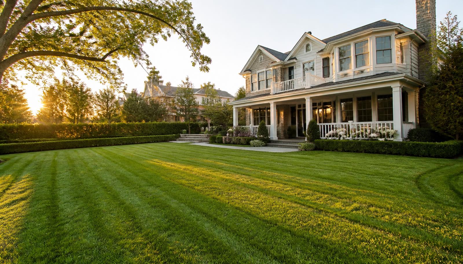 Freshly striped lawn in front of an elegant home maintained by RG Landscaping & Maintenance